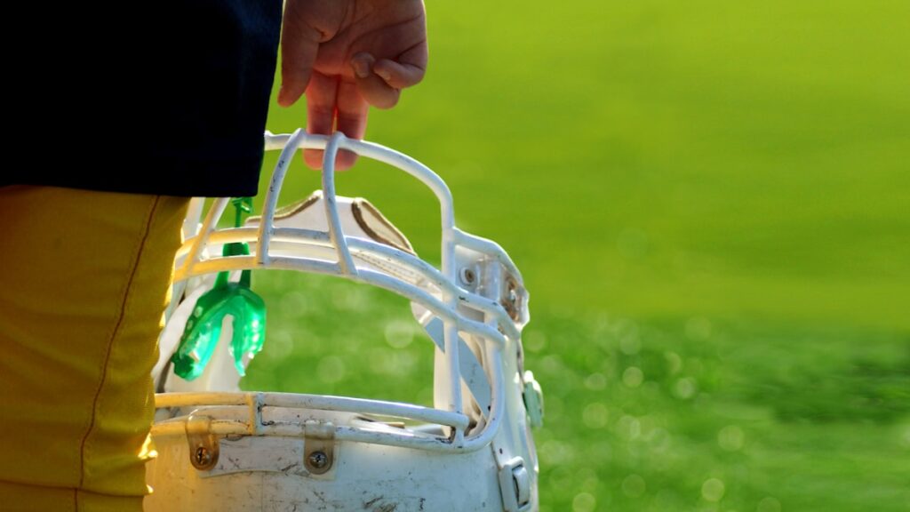 Youth football player holding a helmet